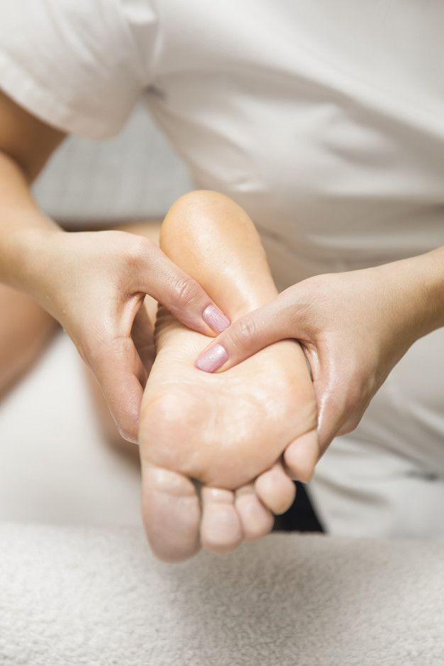 Woman receiving foot massage in spa salon